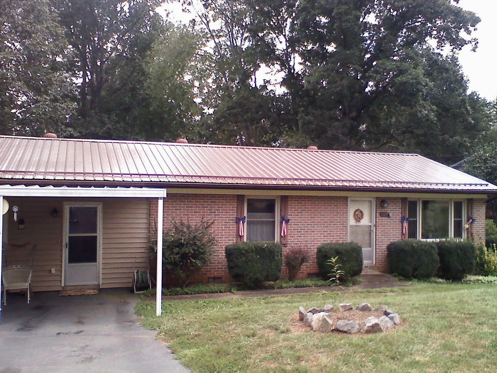 Bronze metal roof and carport on a brick ranch home — Roof Repair work by our crew in Old Monroe